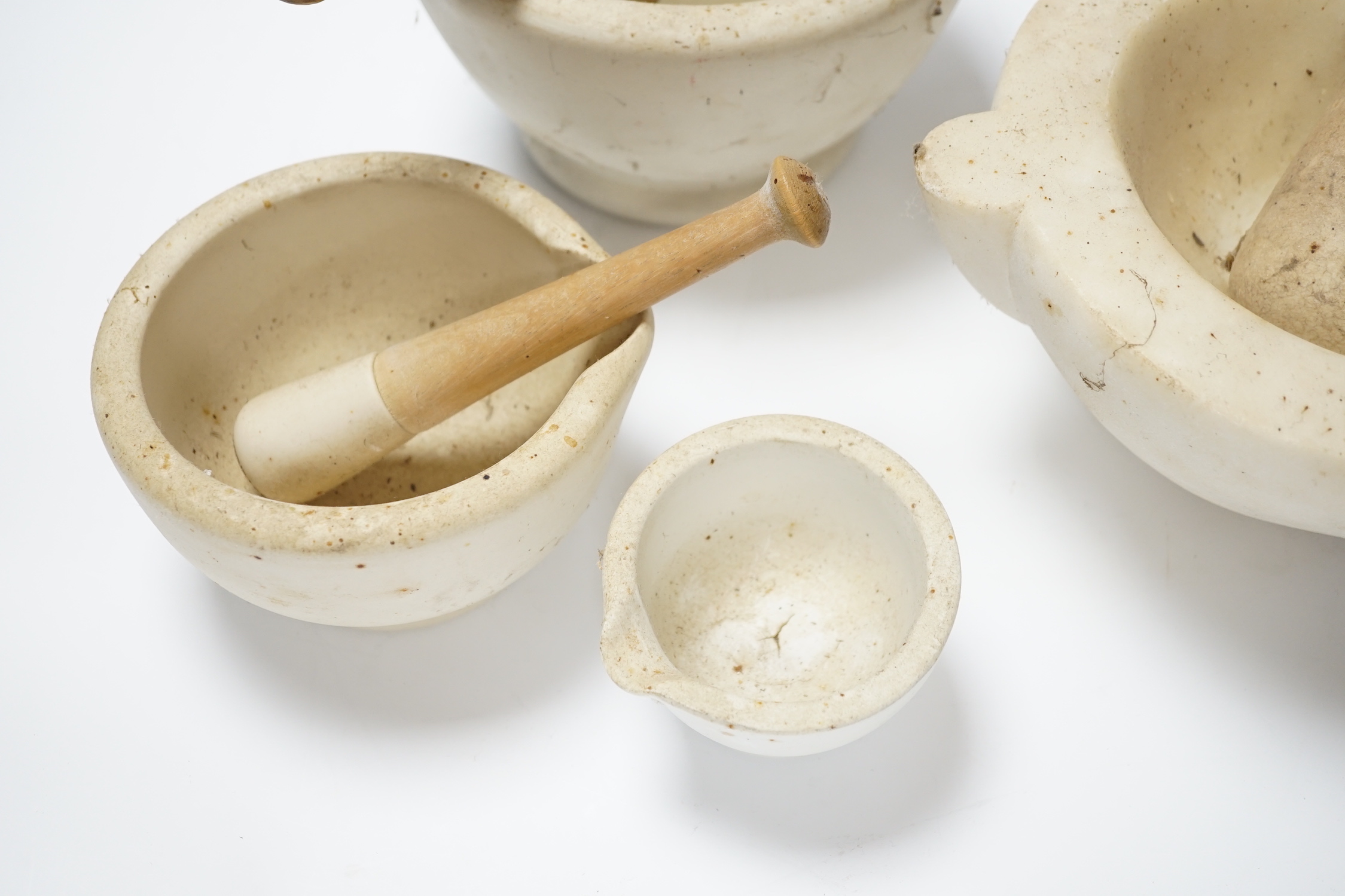 Four mortars and three pestles, largest 23cm wide